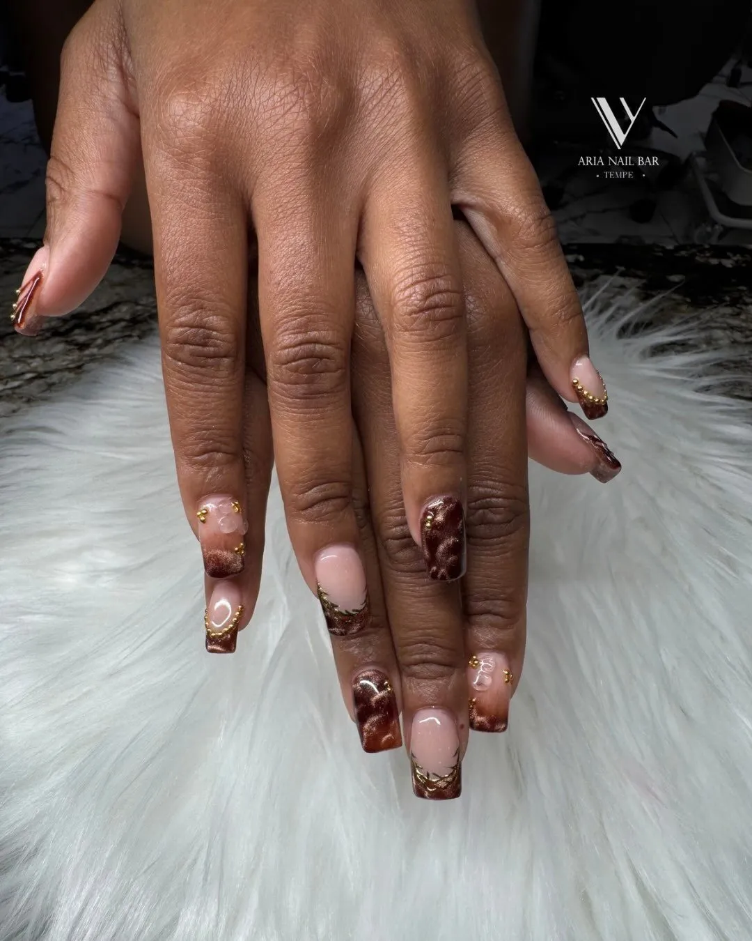 Short square nails with mocha ombre tips and gold bead accents.
