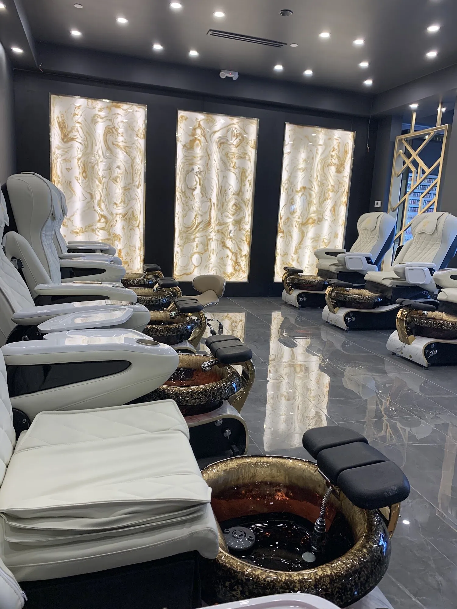 Pedicure chairs beside glowing backlit onyx panels at Aria Nail Bar Scottsdale on Miller Road.